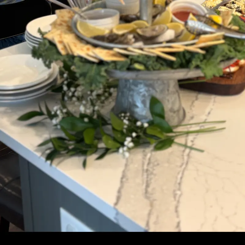 Fresh oyster and seafood raw bar display with lemon wedges and flatbread crisps at a catered event